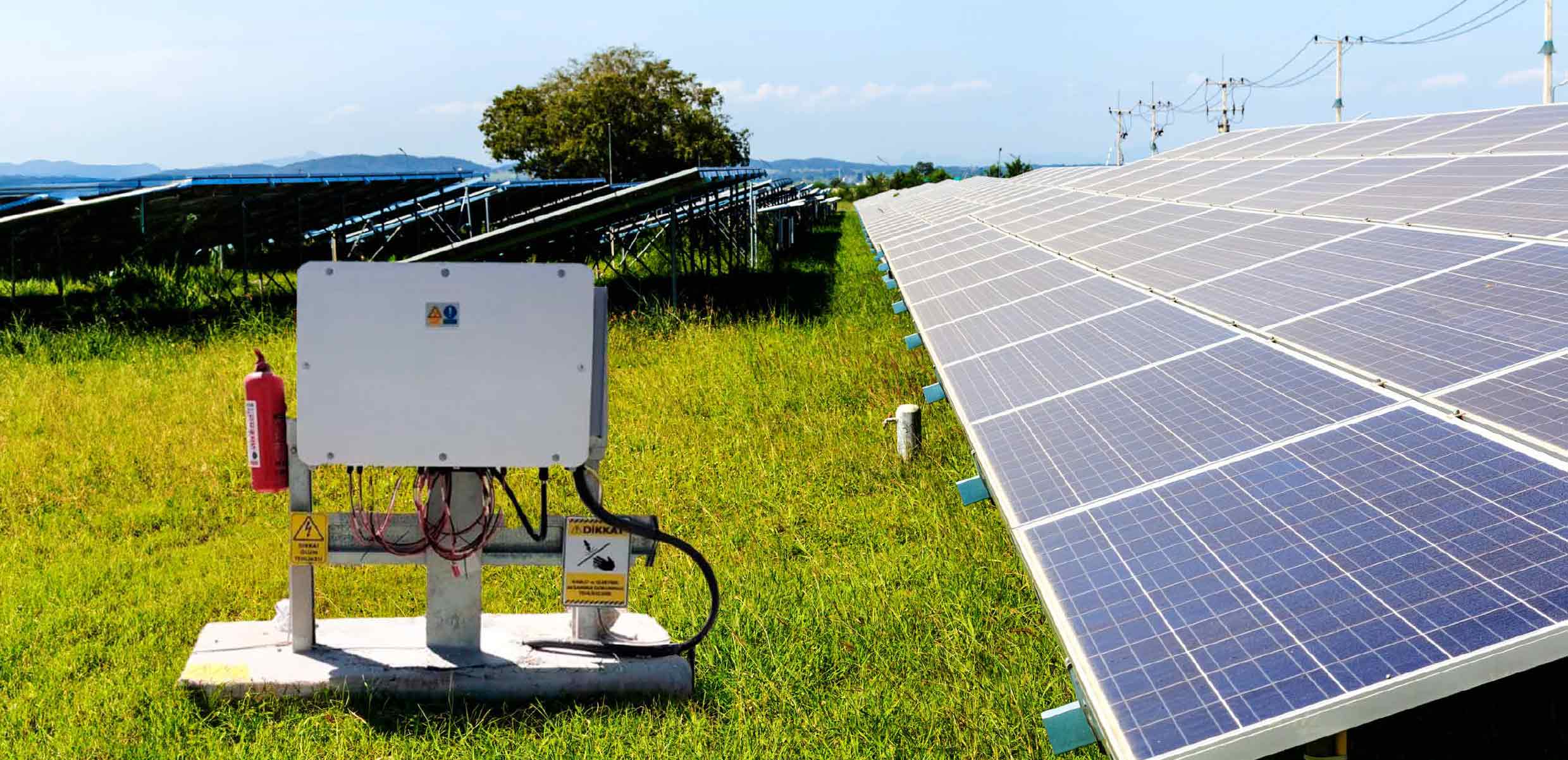 Güneş santrali sahasında panel dizileri yanında kurulu inverter